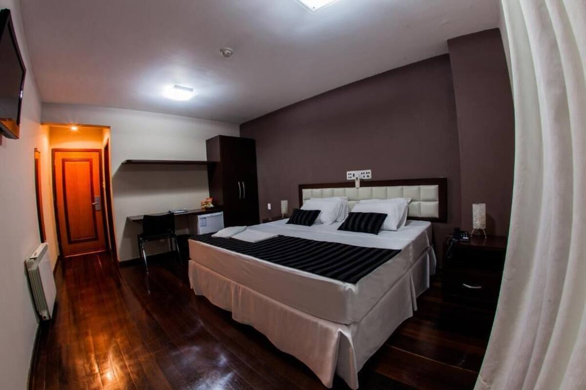 Un dormitorio con una cama grande, un escritorio y un armario.