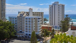 A coastal hotel with multiple floors, a prominent "Olympus" sign, and a view of the ocean. - Serain Residences on View  (Surfers Paradise)