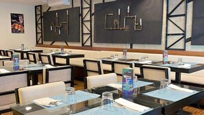 A conference room with tables, chairs, and a large wall art installation. - Fynn Boutique Hotel (Bacoor City)