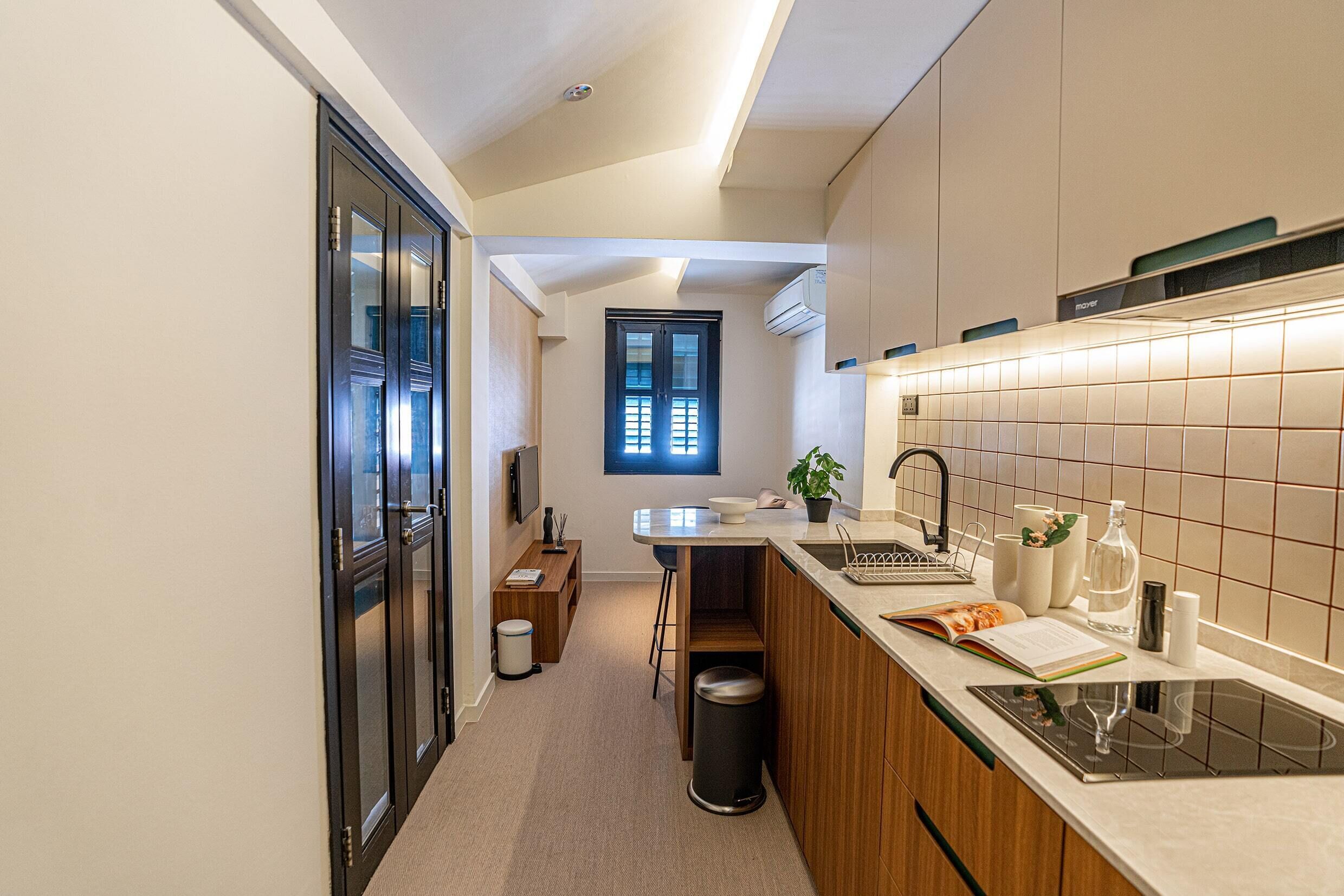 A modern kitchen with a central island, a built-in oven, and a window above the sink.