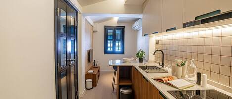 A modern kitchen with a central island, a built-in oven, and a window above the sink.