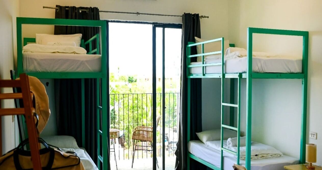 Una habitación tipo dormitorio con literas, una silla y una mesa.