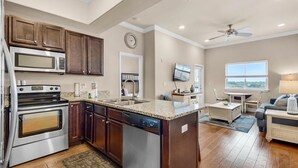 A modern kitchen with granite countertops, stainless steel appliances, and wooden cabinets.