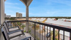 A balcony with a view of a residential area, including houses and high-rise buildings.