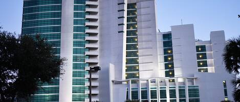 A modern multi-story building with a curved facade, large windows, and balconies.