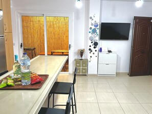 Functional kitchen with central island, dining area access, and flat-screen TV.