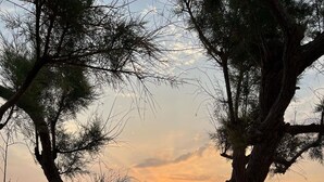 A sunset view with a stone pool and lounge chairs. - Irigoni Studio - Ikaria (Agios Kirykos)