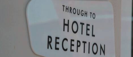 A sign that reads "Through to Hotel Reception."