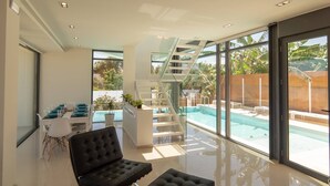 Un interior moderno con piscina, escalera y comedor.