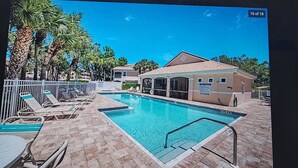 A swimming pool with lounge chairs and a building with a sign that says "No Diving."