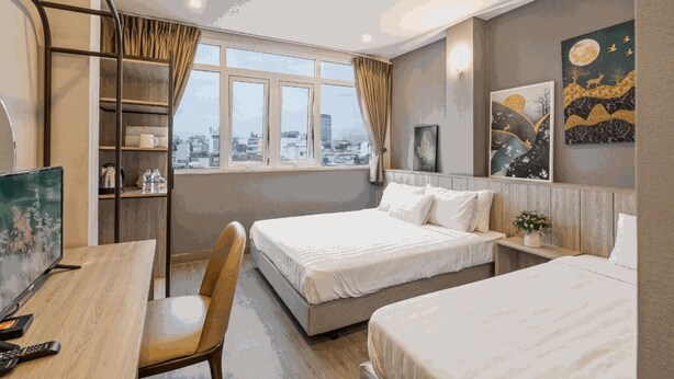 A hotel room with two beds, a desk with a chair, a TV, and a city view through the window. - THE COZY INN (Ho Chi Minh City)