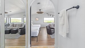 Habitación amplia con una cama grande, dos sillones, un sofá y un comedor con vistas al exterior.