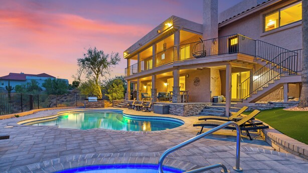 Zona de piscina con una casa al fondo.