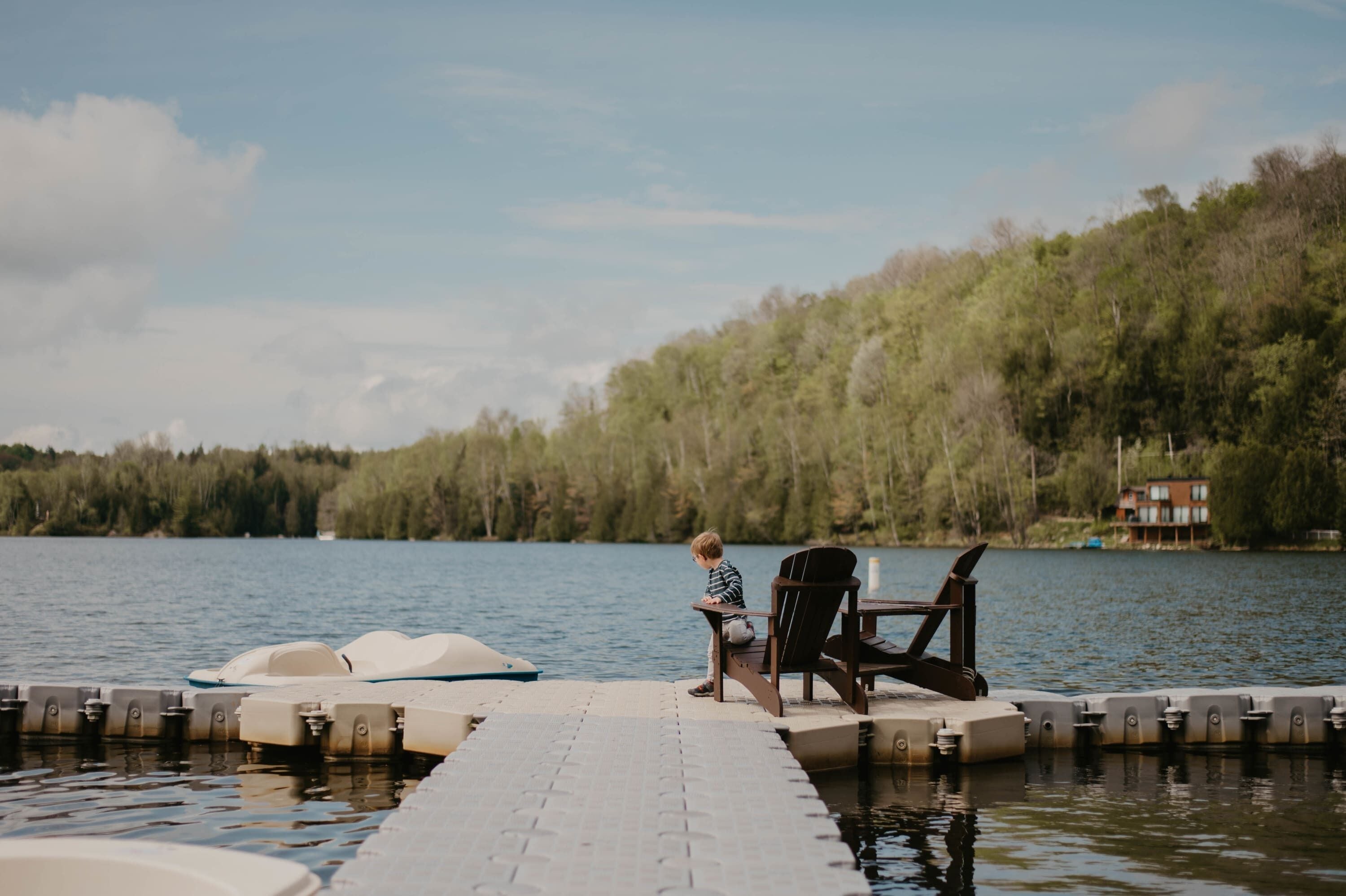 A dock with a chair and a person sitting by the water.