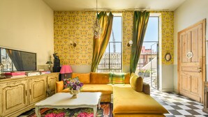 A living room with a checkered floor, a sofa, a coffee table, and a television. - Mediterranean Retreat 2-BR Apt w Rooftop (Tel Aviv)