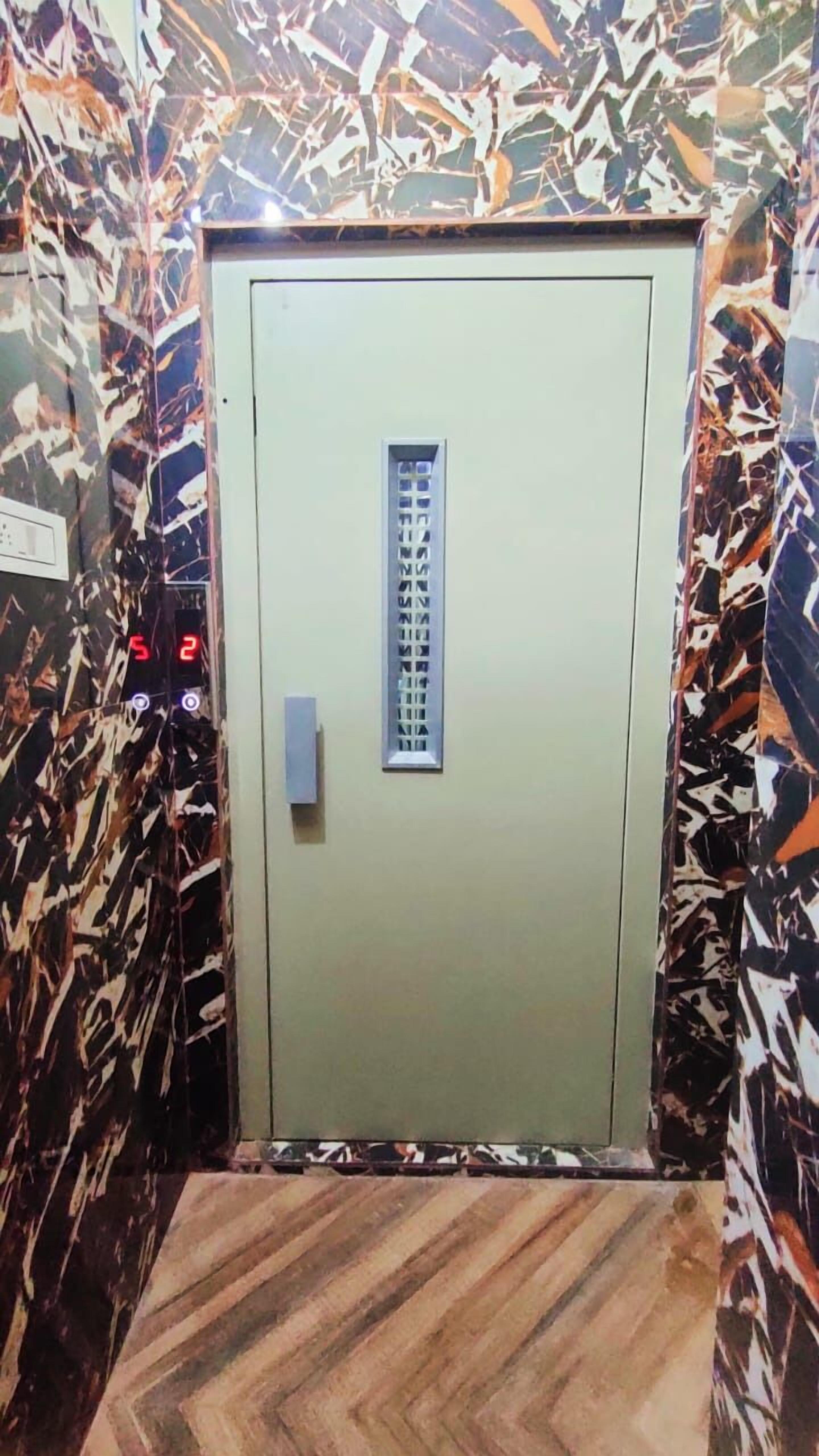 An elevator with a patterned wall and a control panel with buttons.