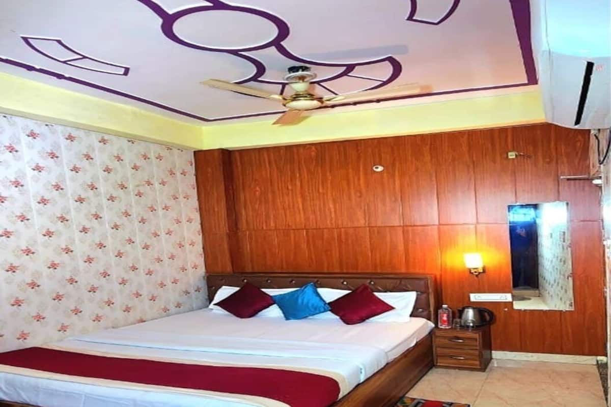 A bedroom with a wooden bed, a ceiling fan, a nightstand, and a mirror.