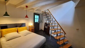 A bedroom with a bed, bedside table, lamp, and a staircase leading to an upper floor. - Country house with garden ★ free pool and jacuzzi ★ Cévennes (Cros)