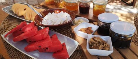 A table with various food items including watermelon, nuts, and jars of preserves.