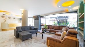 A modern reception area with a sofa, armchairs, and a coffee table.