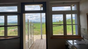 Una habitación con ventanas amplias que ofrecen vistas a un paisaje verde.
