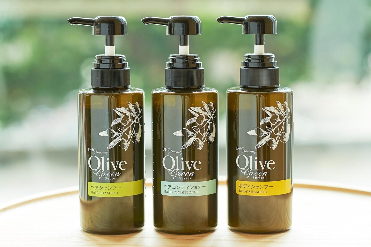 Three bottles of Olive Green Series hair products on a table.