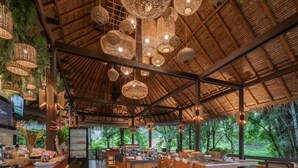 A restaurant with a thatched roof, wicker hanging lights, and a buffet setup. - Phapok Eco Resort (Suan Phueng)