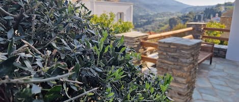 Un pati amb escales de pedra i vistes a les muntanyes al fons.