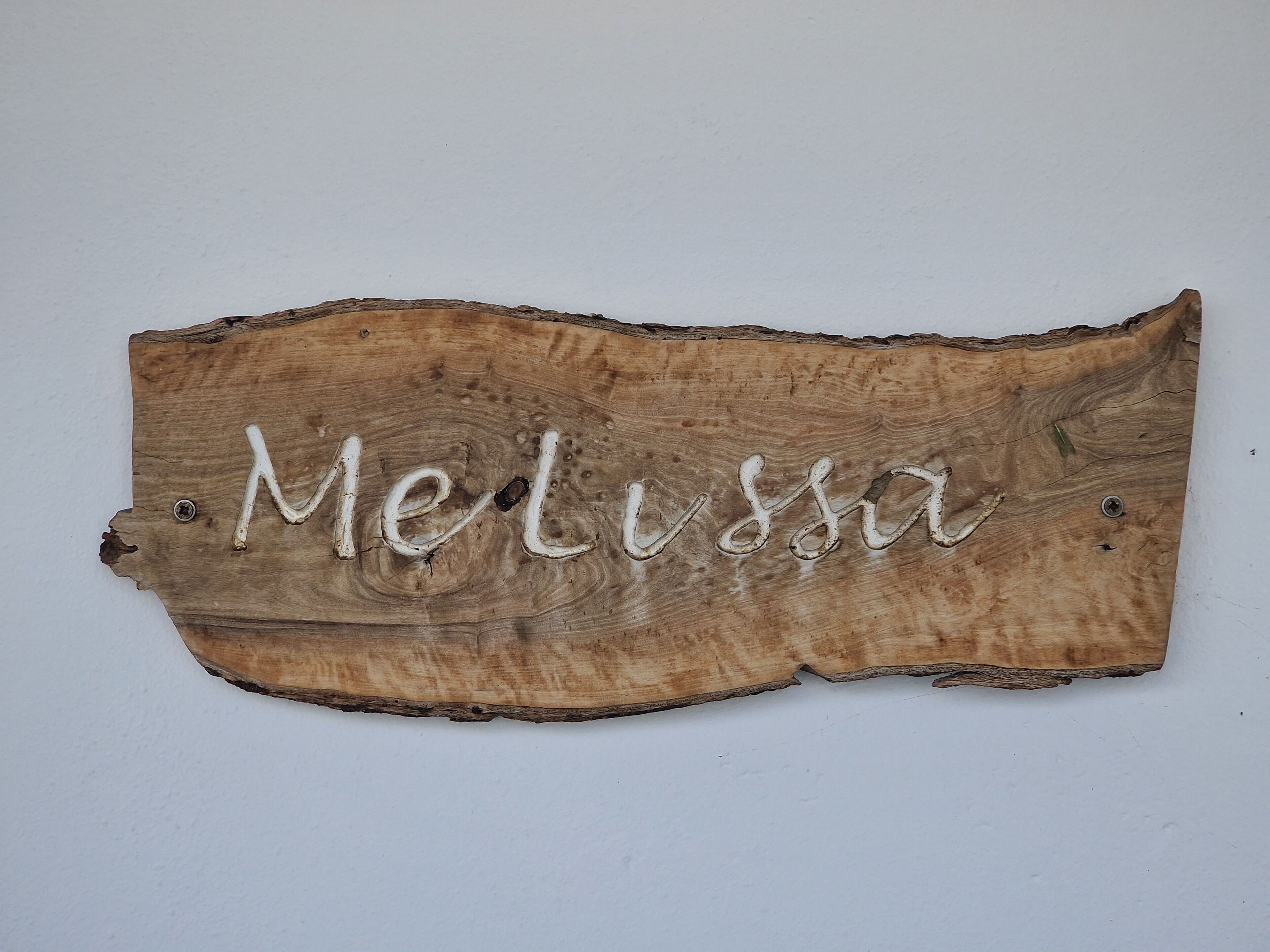 Een houten bordje met de naam 'Melissa' erin gebeiteld.