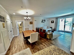 A spacious living area with a dining table, seating, and a view of the outdoors.