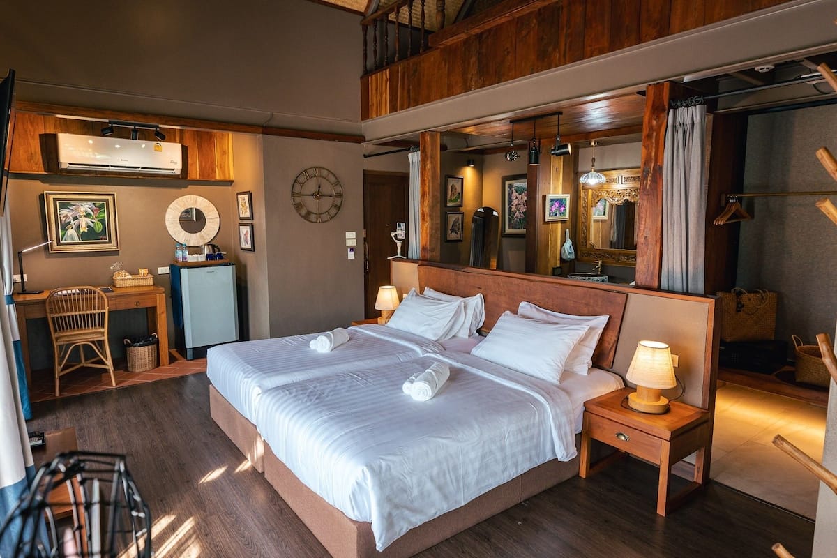 Een hotelkamer met een groot bed, een bureau en een spiegel.