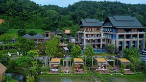 Et resort med flere bygninger, en swimmingpool og frodig vegetation omkring.