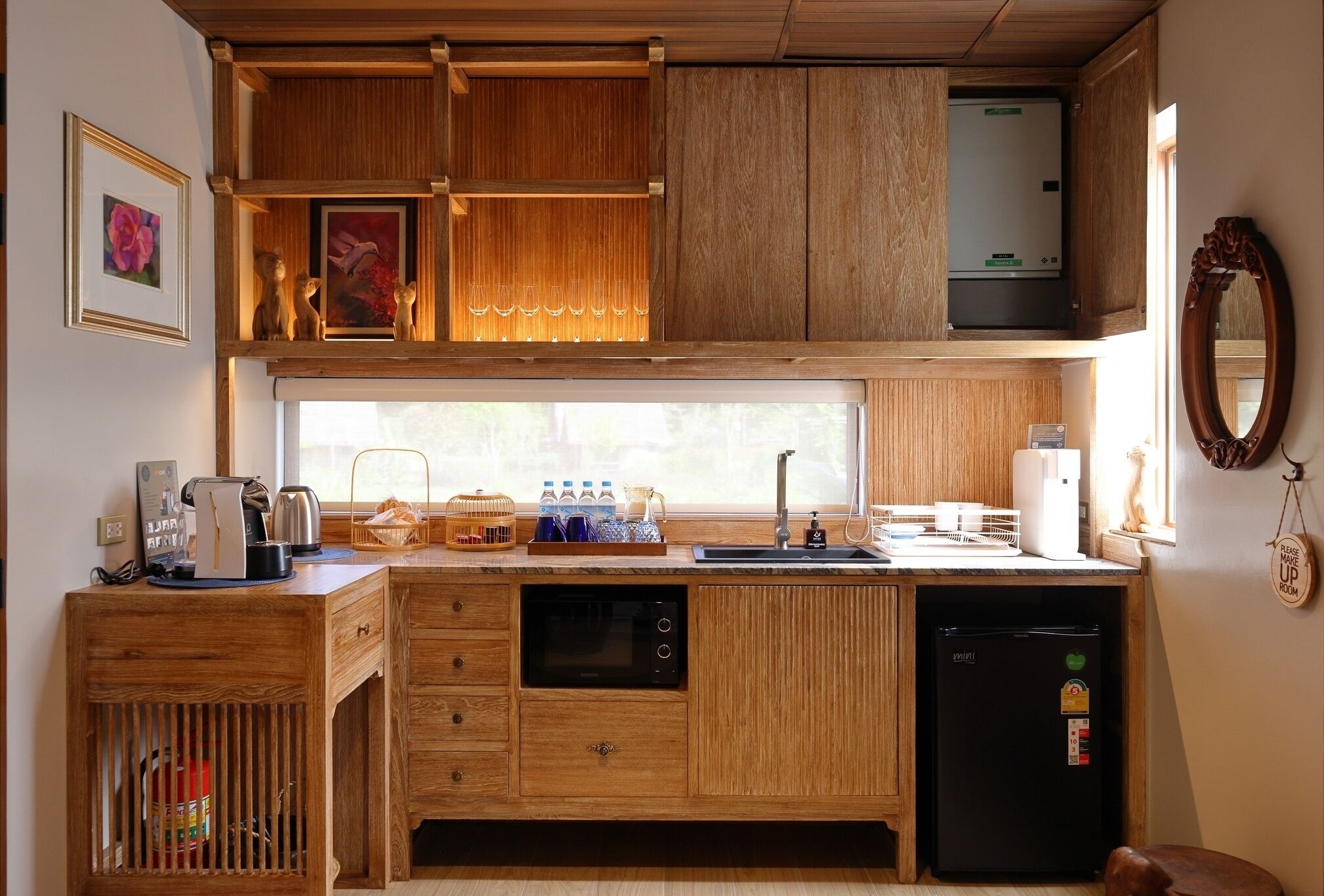 A compact kitchen with wooden cabinetry, a built-in oven, a refrigerator, and a window providing natural light.