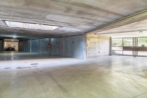 An empty parking garage with concrete floors and metal garage doors. - Vivi Il Lago - Lake View (Cernobbio)