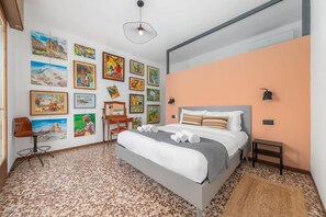 Ein modernes Schlafzimmer mit einem Bett, Kunstwerken an den Wänden und einem außergewöhnlichen Fußbodenmuster.