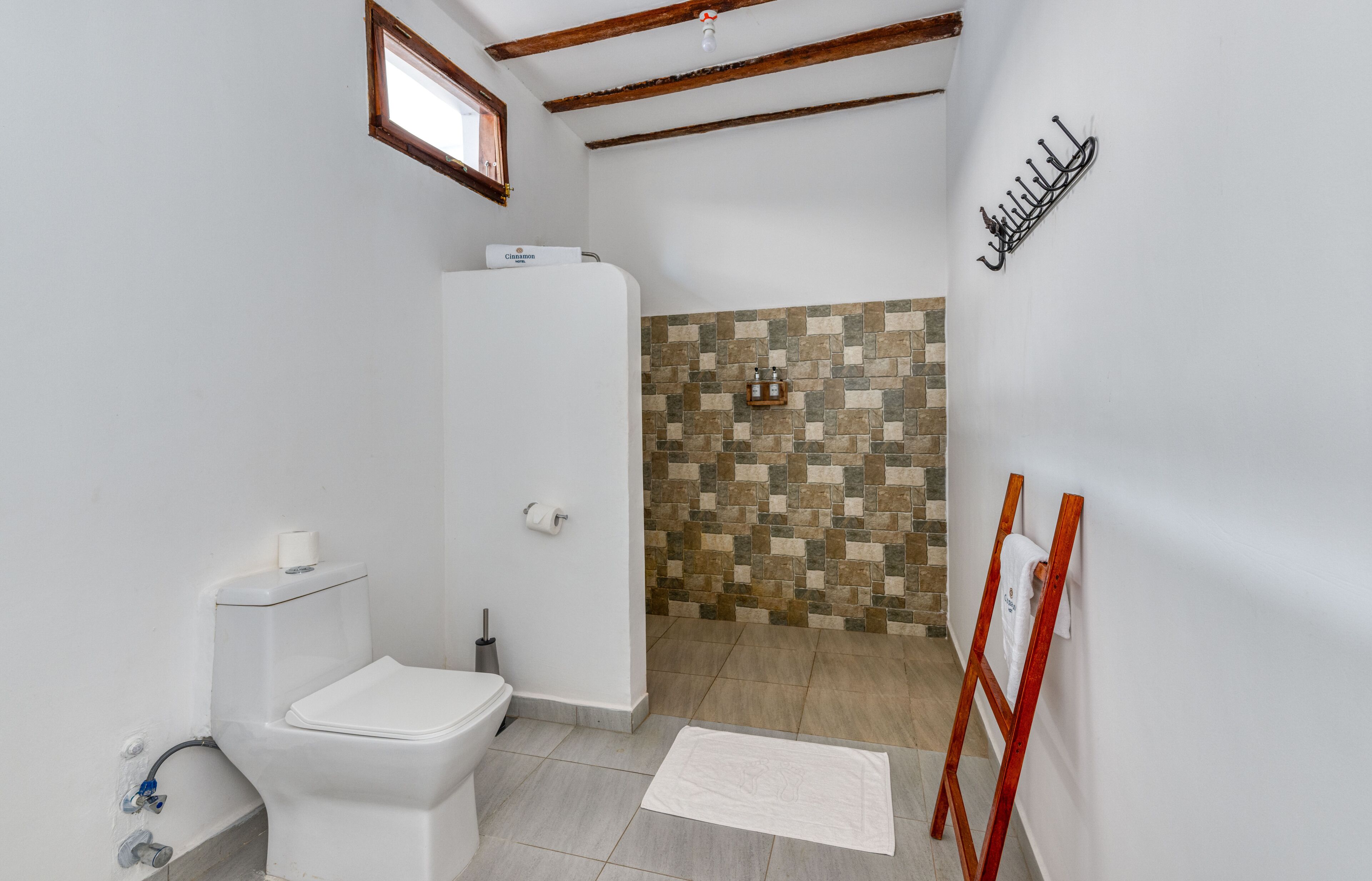 Ein Badezimmer mit Toilette, Dusche und Fliesen.