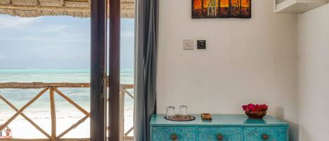 Una habitación con vista a la playa, un aparador azul y un cuadro en la pared.