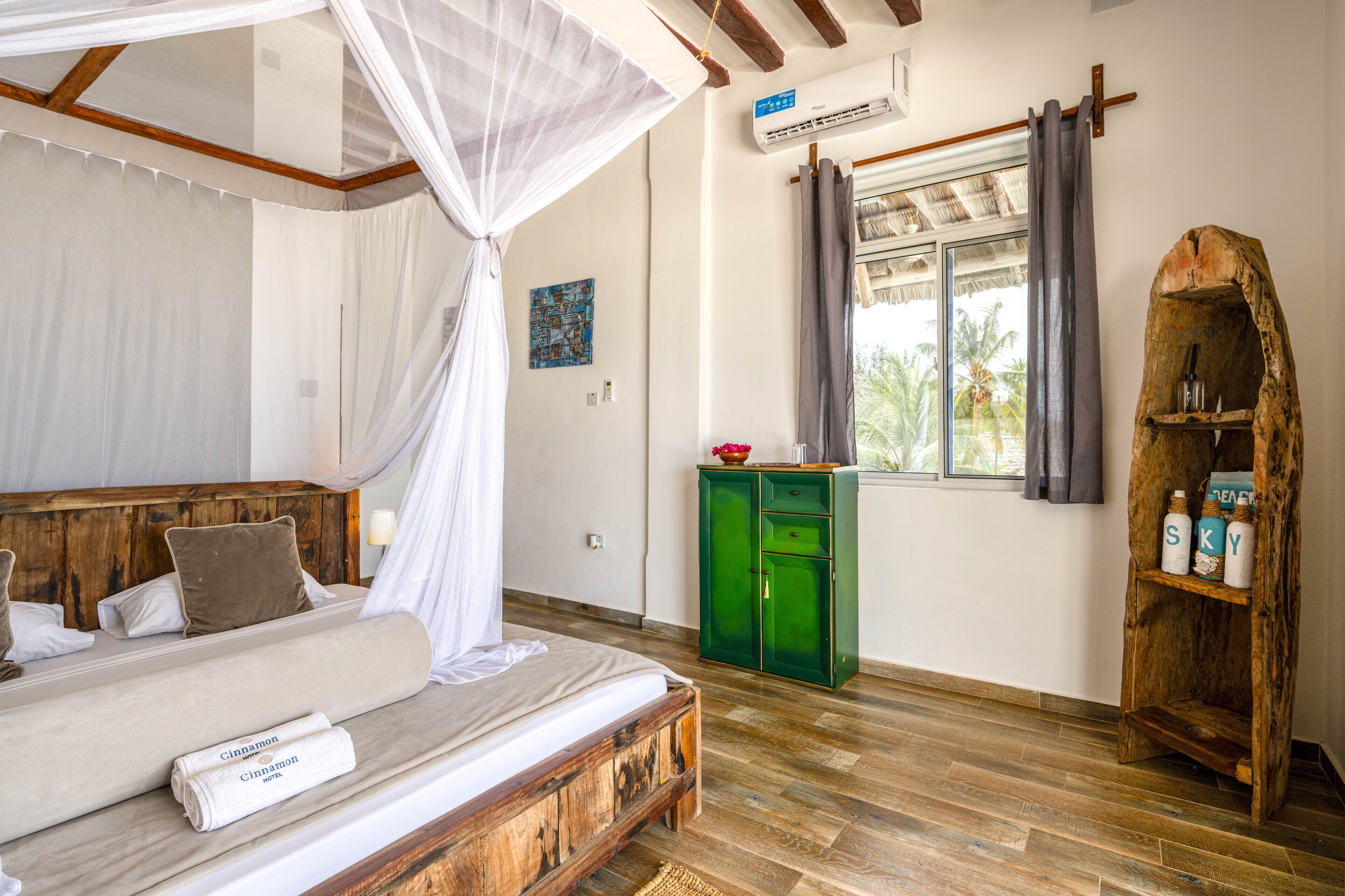 A bedroom with a wooden bed, a green cabinet, and a rustic wooden shelf.
