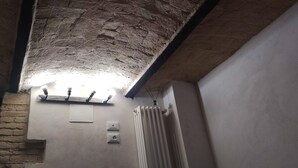 Ein Zimmer mit freiliegendem Ziegelstein-Gewölbe, einem Heizkörper und zwei Steckdosen.