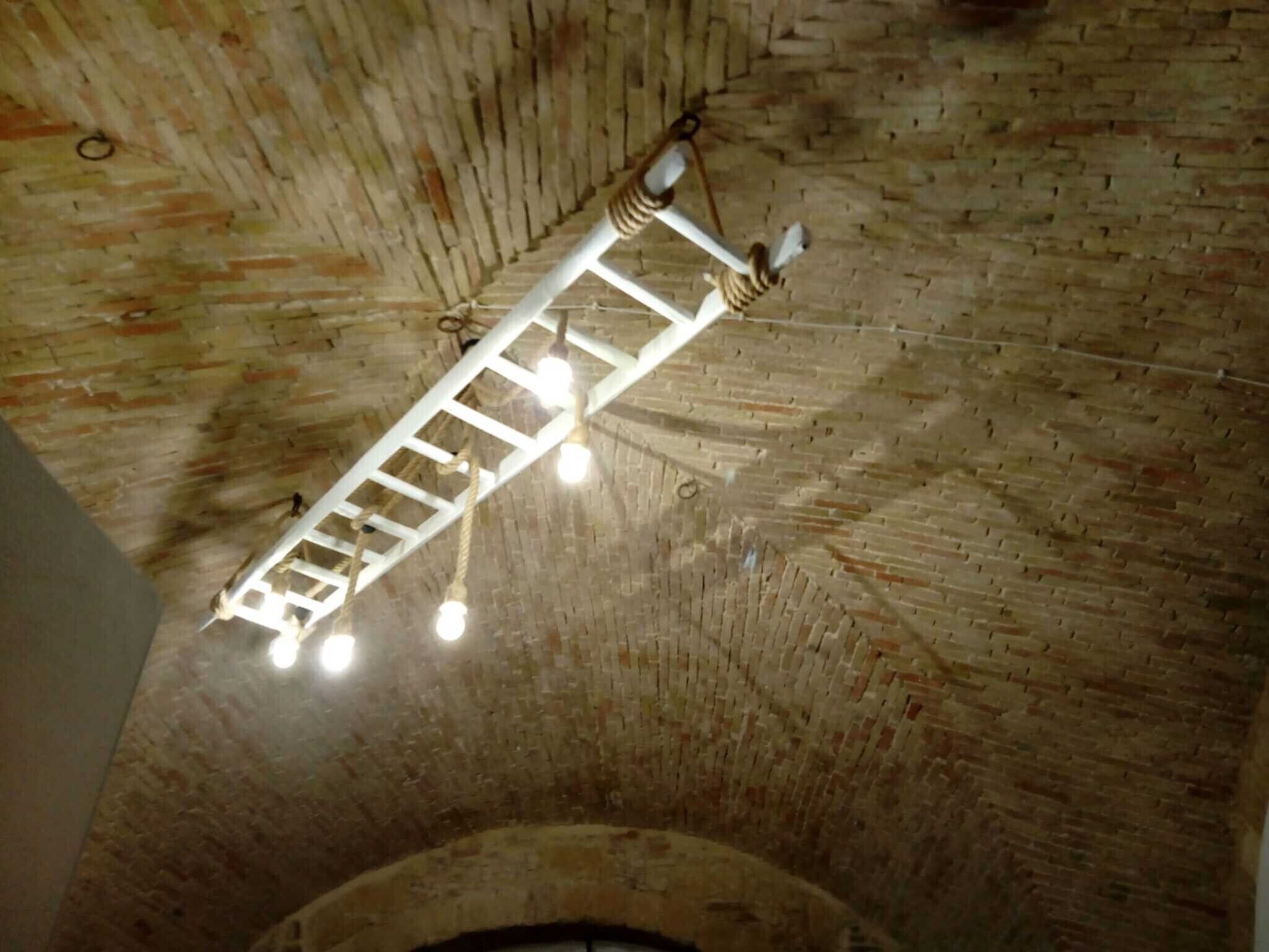 Eine Ziegeldecke mit einer weißen, leiterartigen Struktur und hängenden Lampen.