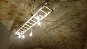 Eine Ziegeldecke mit einer weißen, leiterartigen Struktur und hängenden Lampen.