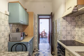 Une petite cuisine équipée d’un four à micro-ondes, de placards et d’une cuisinière.