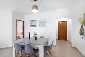Een eetgedeelte met een tafel, stoelen en kunst aan de muur.