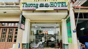 Entrada de hotel con un cartel que dice "Thuong Do Lin HOTEL" e información de contacto.