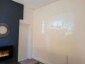 Cozy meeting space with a fireplace and large presentation screen.