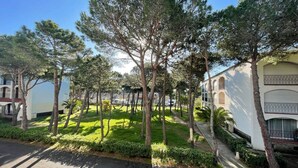 A courtyard with trees, a pathway, and a building with arched windows and balconies. - **Cozy Seaside Studio with Balcony, 200m from Beach, Sleeps 4** (Argelès-sur-Mer)