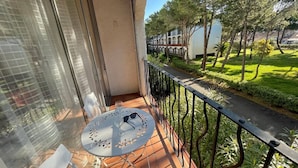 A balcony with a table, chairs, and a glass door. - **Cozy Seaside Studio with Balcony, 200m from Beach, Sleeps 4** (Argelès-sur-Mer)