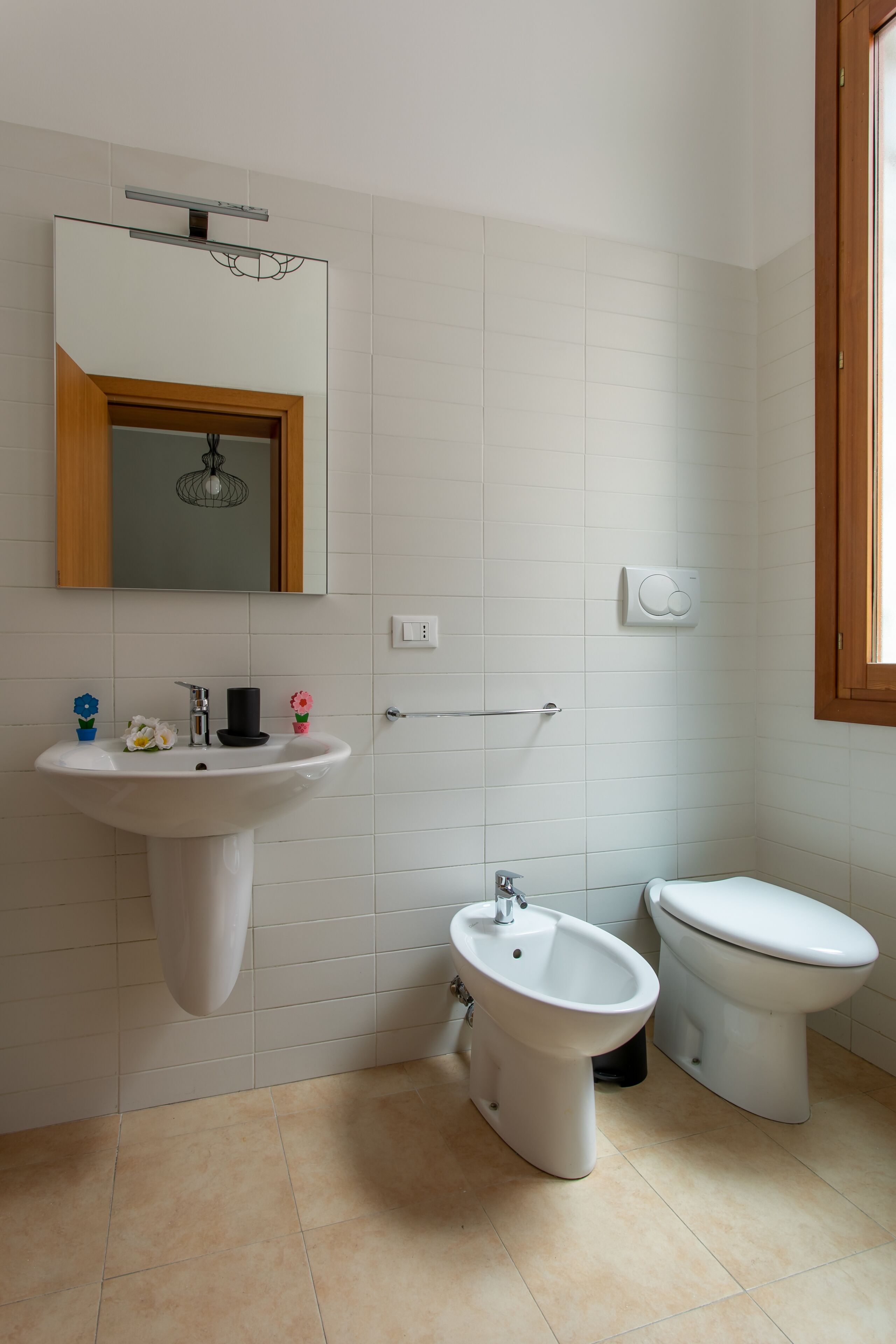 A bathroom with a pedestal sink, a bidet, and a toilet.