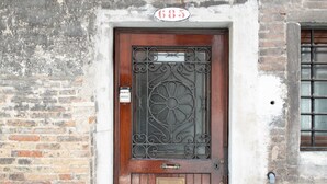 A wooden door with a metal grille and a plaque reading "585" above it. - Rialto Bridge Lovely Apartment (Venice)