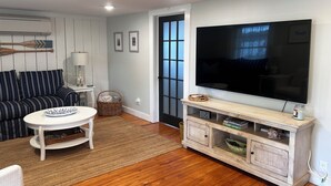A living room with a sofa, a coffee table, a TV, and a wooden cabinet.